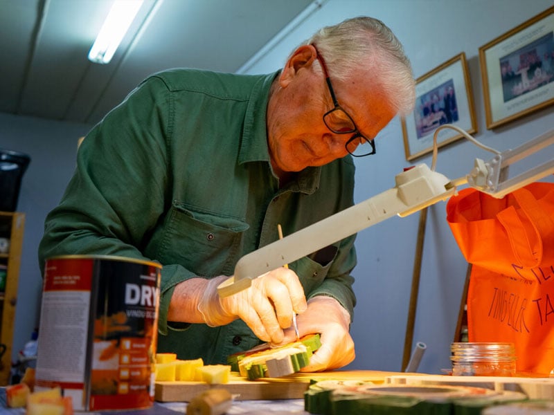 Einar M. Hårstad er svært fokusert i det han pent legger på et strøk maling på et av stykkene han har laget.