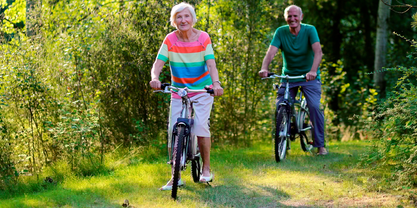 Mann og dame på sykkeltur i skogen