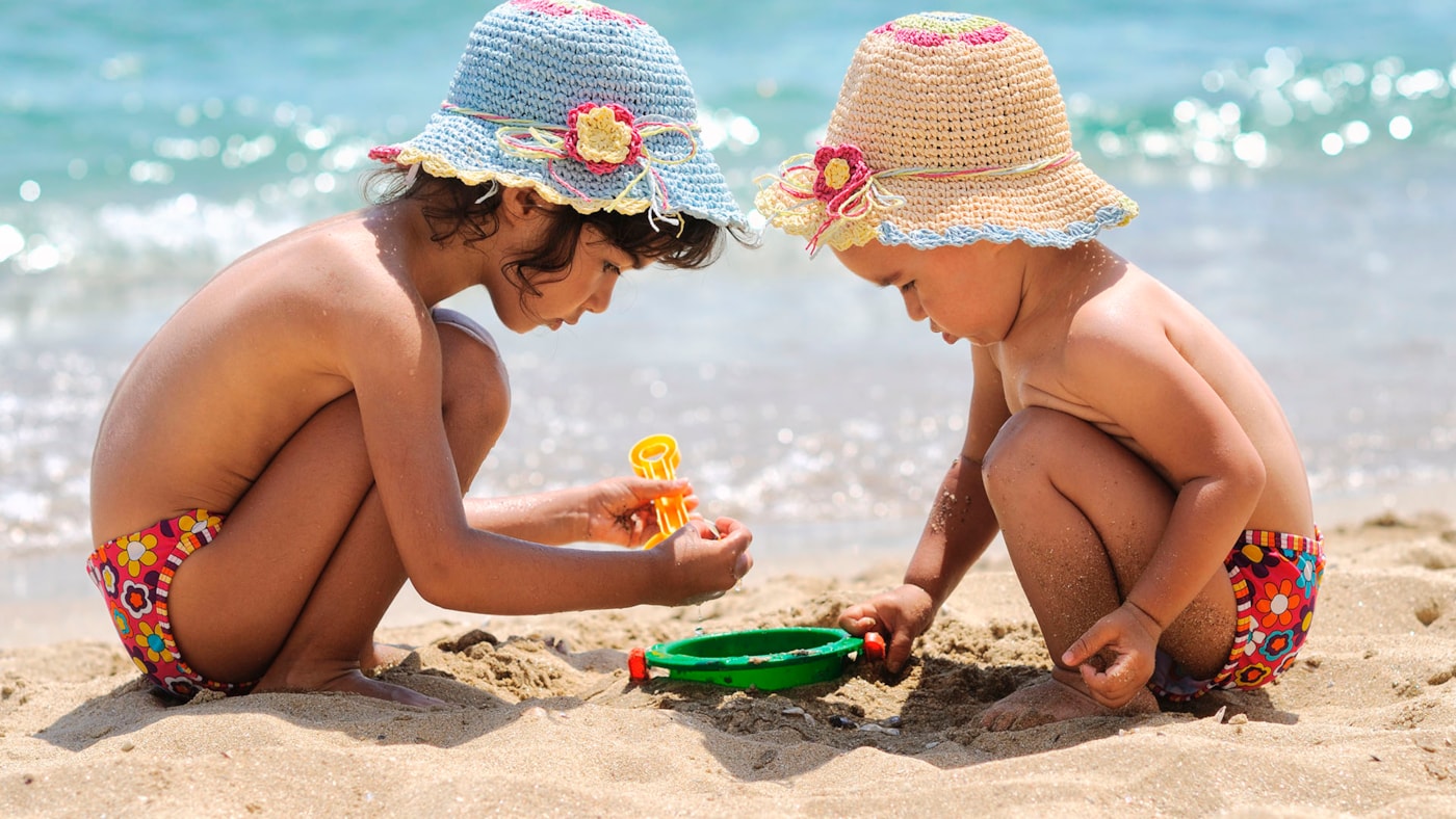 Barn på stranden, sommer og sol og lek