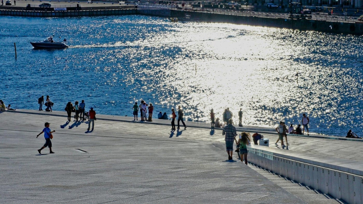 Mennesker i sommersol ved Operaen i Oslo