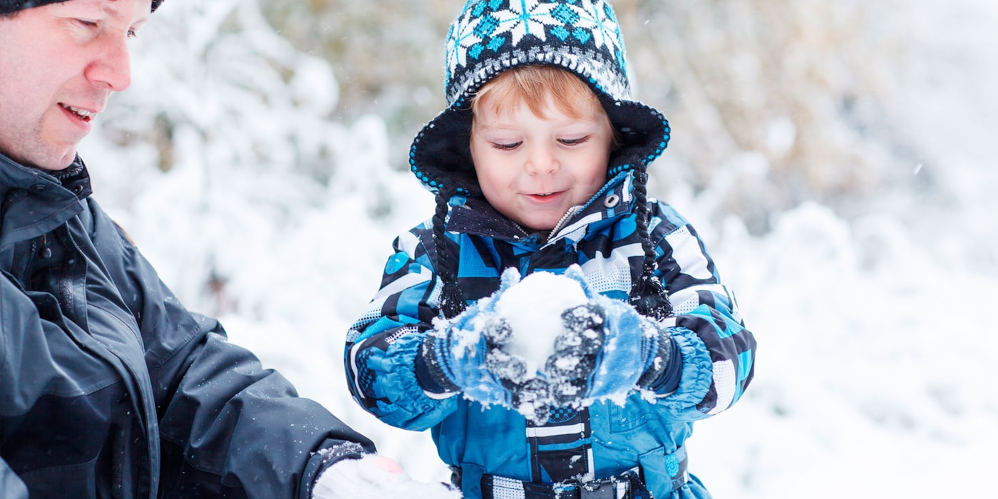 Gutt og far leker i snø