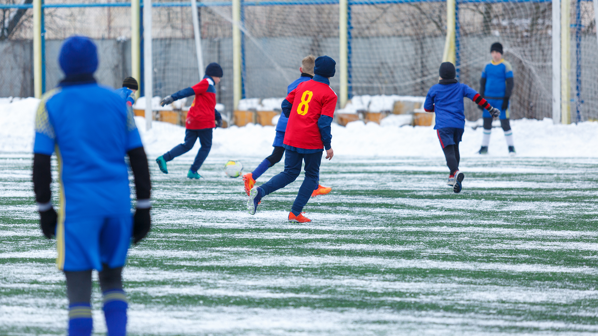 Barn som spiller fotball utendørs på vinteren