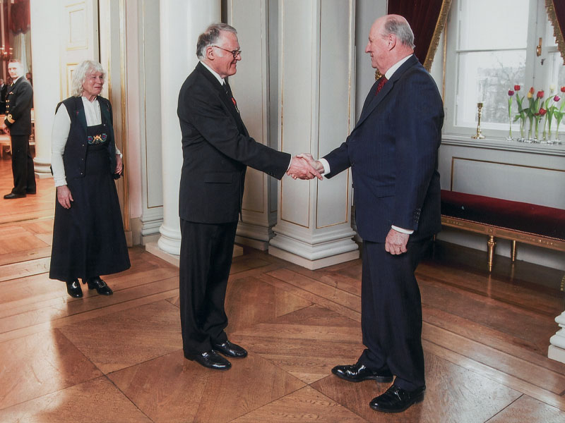 Kjell Alstad takker Kong Harald etter å ha mottatt Kongens fortjenestemedalje høsten 2009. Bak står kona Christin Thorvig Alstad.