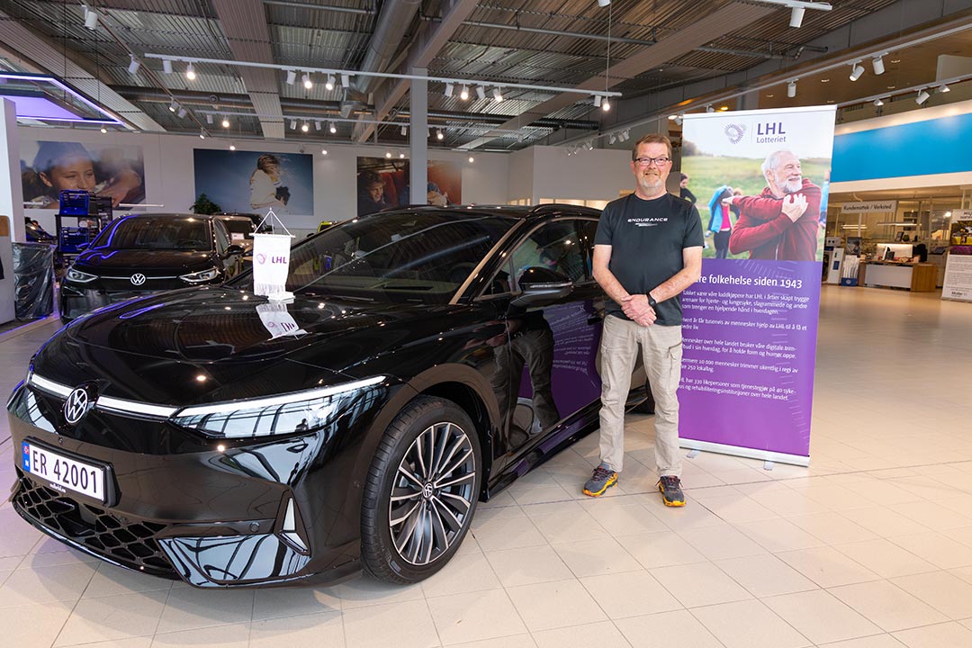 Hans Ove Steinsgard foran sin nye Volkswagen ID.7 som var premie i LHL-Lotteriet
