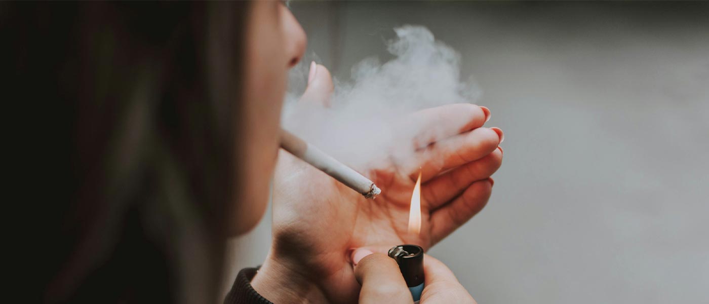 Bilde av ung kvinne som tenner en sigarett