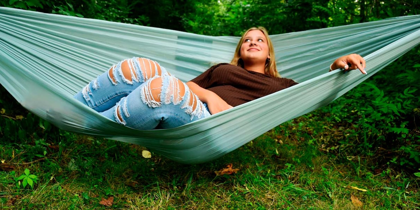 Jente i hengekøye i hagen