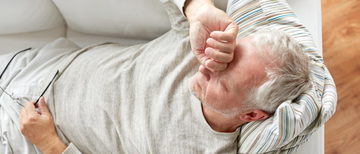 Mann ligger på sofa