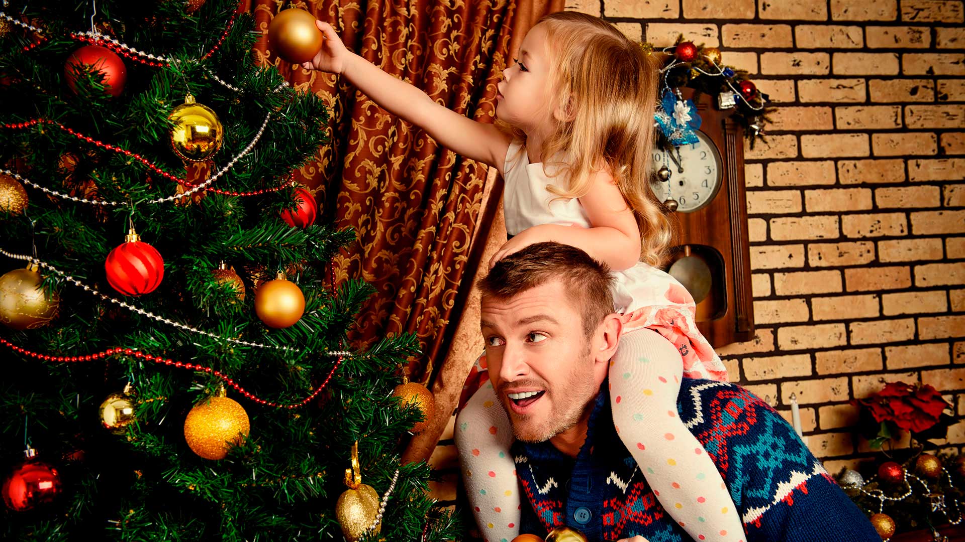 Bilde av far og datter som pynter juletreet sammen.