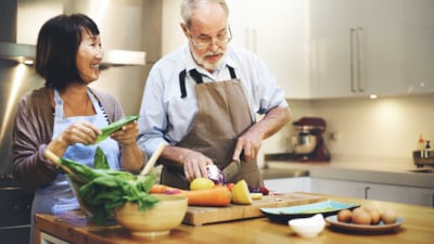 Kvinne og mann lager mat sammen på kjøkkenet