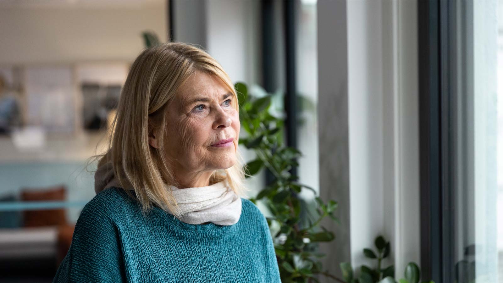 Tankefull dame ser ut av vinduet